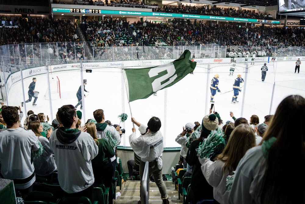 <p>MSU hockey fan waves the Spartan flag after MSU scores their second goal of the night (3-2) on Feb. 4, 2023.</p>