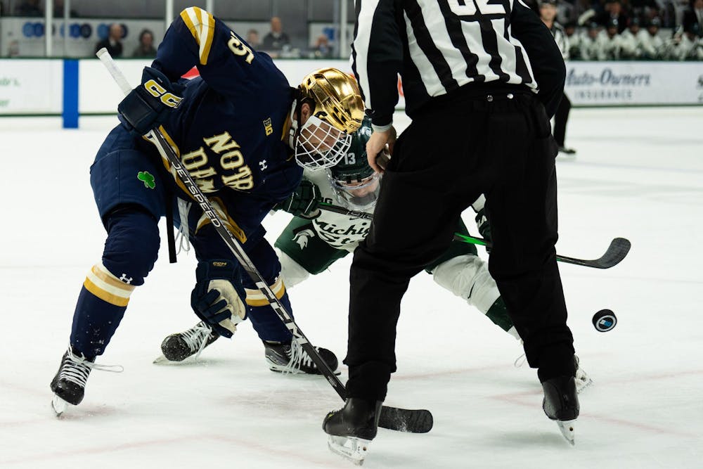 <p>Michigan State junior forward Tiernan Shoudy (13) and Notre Dame sophomore forward Jayden Davis (15) fight for the puck during a face-off at Munn Ice Arena on March 15, 2025. The Spartans took a 1-0 victory over the Fighting Irish, advancing to the Big Ten Championship.</p>