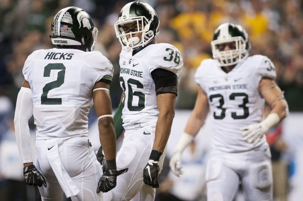 Senior cornerback Arjen Colquhoun looks to junior cornerback Darien Hicks after breaking up a Hawkeye pass in their end zone on Dec. 5, 2015 during the Big Ten championship game against Iowa at Lucas Oil Stadium in Indianapolis. The Spartans trail the Hawkeyes, 6-3, at the half.