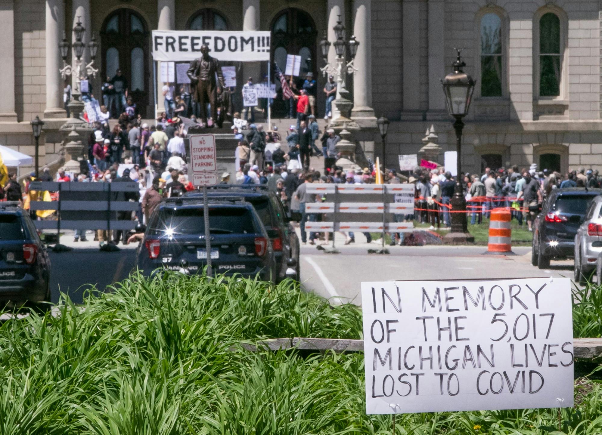 <p>Lines gather in front of the Capitol as people wait to get their haircut at the #OperationHaircut protest in Lansing on May 20, 2020.</p>