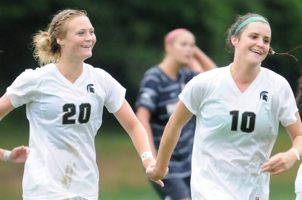 Junior forward Olivia Stander celebrates with sophomore defender Annie Steinlage after scoring a goal in the last five minutes of the second half, advancing the score to 3-2. MSU defeated University of Detroit Mercy in overtime, 4-3, at DeMartin Stadium at Old College Field Wednesday afternoon. Justin Wan/The State News