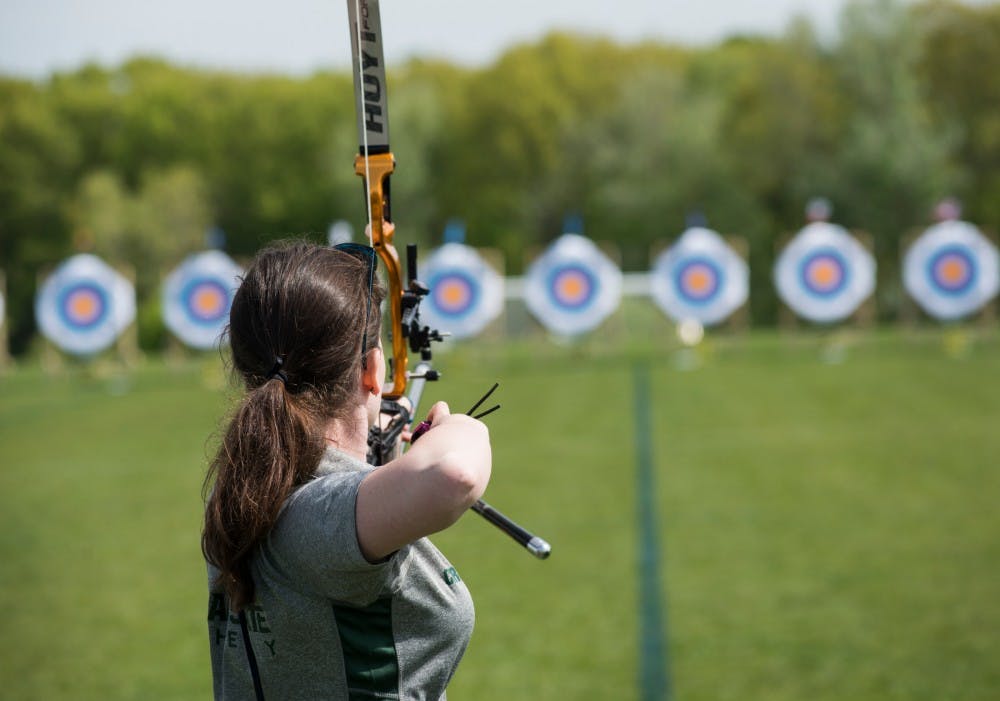 Biochemistry sophomore Carolyn Graham shoots an arrow from her recurve bow during the qualification round of the U.S. National Outdoor Collegiate Championship on May 21, 2016 at Hope Sports Complex, 5801 Aurelius Road, in Lansing. This event was for members of the USA Archery Collegiate Archery Program and offers competitive divisions for recurve, compound, bowhunter and barebow archers. 