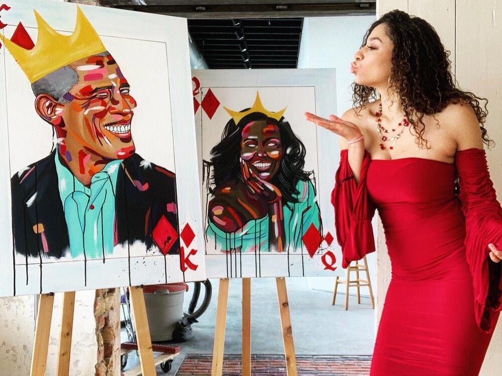 Lansing-based artist Mila Lynn poses with her portraits of Barack and Michelle Obama, which are part of her 'Black is King' project. Photo courtesy of Mila Lynn.