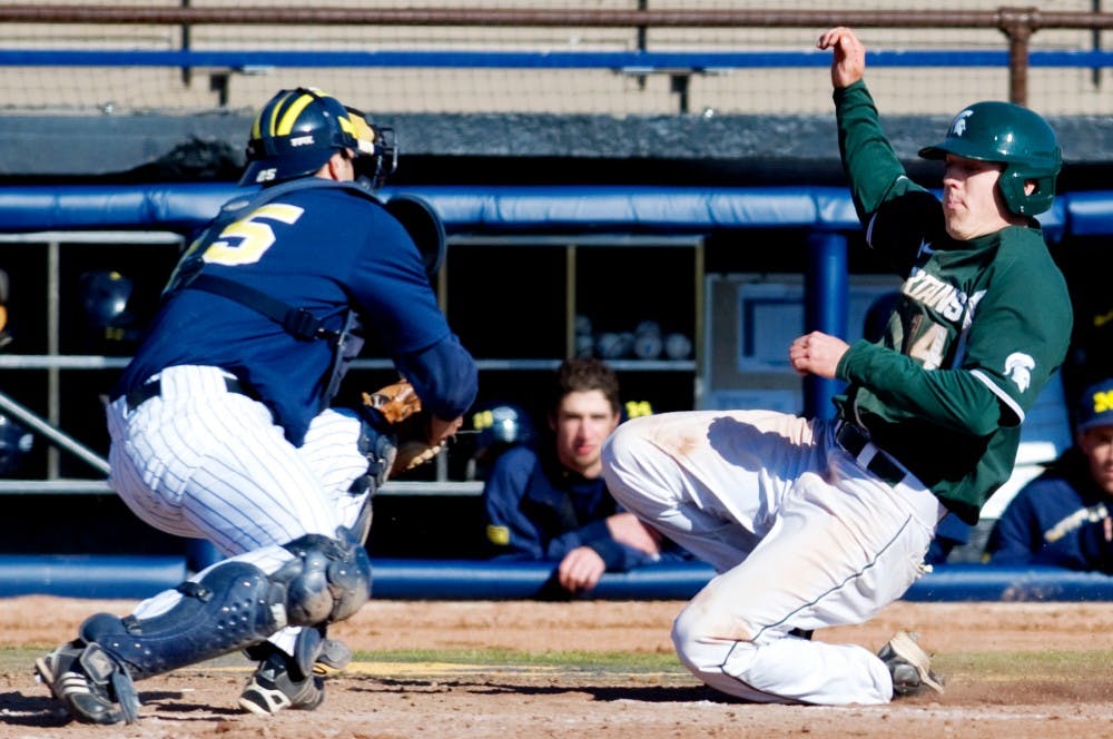 Senior center fielder Brian Eckerle slides as Michigan catcher Zach Johnson attempts to guard the plate March 27 at Ray Fisher Stadium at Wilpon Baseball Complex in Ann Arbor. The Spartans defeated the Wolverines, 8-2 to take both games of a double header. Matt Radick/The State News