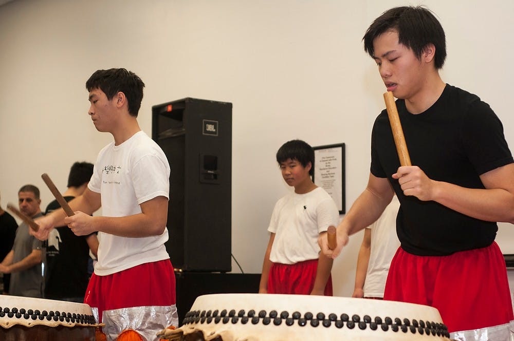 	<p>Northville, Mich., residents Andy Tang, left, and Nathan Low, right, play Chinese drums for the lion dance Nov. 17, 2013, at Brody Hall Complex. The Global Festival gave the Lansing community a chance to explore cultures from all around the world.</p>