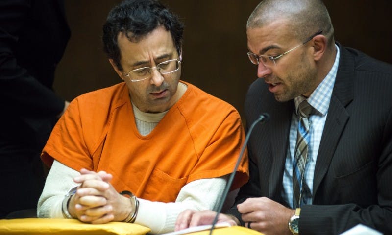 <p>Former MSU employee Larry Nassar, left, converses with his defense attorney, Matt Newburg, during a preliminary examination conference on March 2, 2017 at 55th District Court in Mason, Mich. Nassar's preliminary examination was deferred to May 12, 2017.</p>