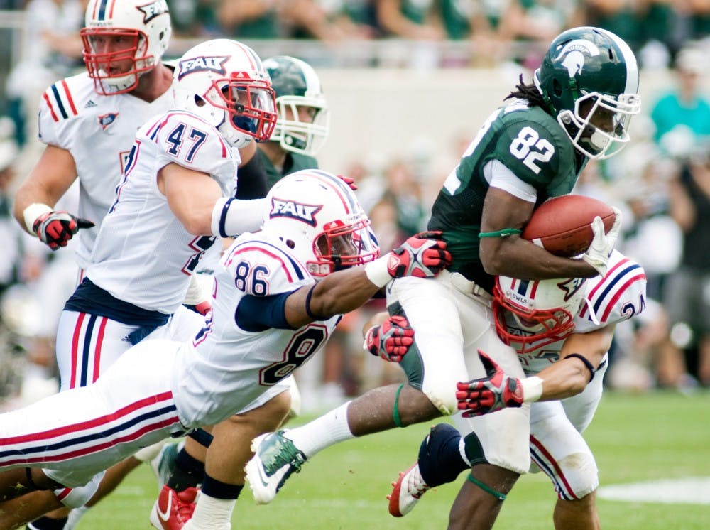 Senior wide receiver Keshawn Martin maintains possession of the ball as Florida Atlantic wide receiver Hakeeme Ishmar, left, and defensive back Brentley Harstad, right, attempt to tackle him during the first half of Saturday's game in Spartan Stadium. Martin gained 72 yards throughout the game. Lauren Wood/The State News