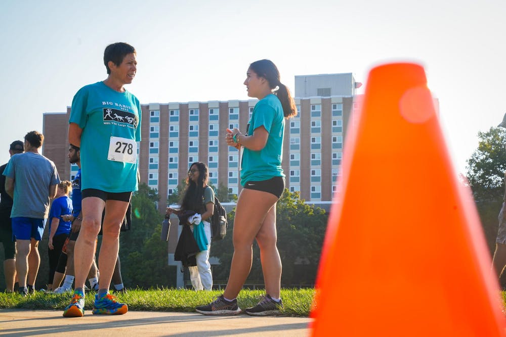 Two participants chat moments before the Big Babies 5k Run begins at Conrad Hall on Sep. 15, 2024.