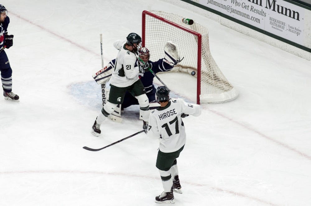 Senior forward Joe Cox (21) attempts to redirect a shot on net during an exhibition game against the University of Toronto on Oct. 2, 2016 at Munn Ice Arena. The Spartans defeated the Blues 2-1 in an overtime shootout after ending regulation in a 2-2 tie. 