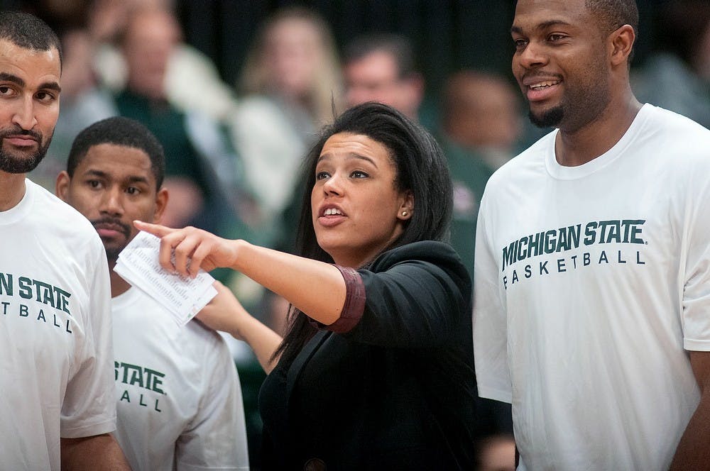 Assistant coach Lauren Aitch instructs MSU former forward Jon Garavaglia, left, MSU former guard Charlie Bell, center, and MSU ex-center Idong Ibok, right, on the sidelines of the MSU alumni basketball game at Jenison Field House on Friday. Aitch, along with MSU football head coach Mark Dantonio, helped the White team beat the Green team, 125-118. Danyelle Morrow/The State News