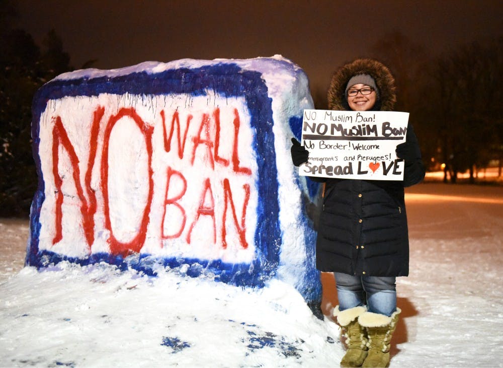 Lansing resident Aaliyah Buell poses with her poster on Jan. 31, 2017 at The Rock. The Michigan State Muslim Students' Association hosted a "No Ban, No Wall: Spartans for Sanctuary and Solidarity" as a response to President Trump's executive order on immigrants and refugees.