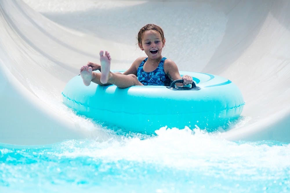 <p>Westphalia, Mich., resident Carlee Fox, 6, goes down a water slide during the 2014 Summer Splash event, July 30, 2014, at the East Lansing Family Aquatic Center. The event celebrates the 14th anniversary of the center. Corey Damocles/The State News </p>