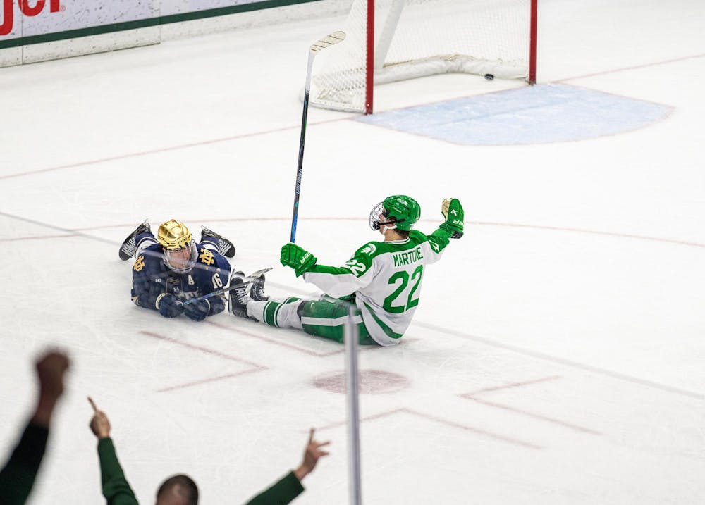 MSU Fr. F, Porter Martone (22), scores a goal and slides across the ice sitting down after Notre Dame puts all of their players on the attack leaving an open net in Munn Ice Arena in East Lansing, MI on Feb. 19, 2026.