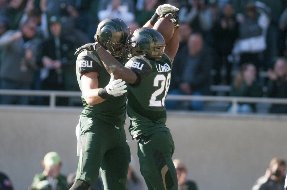 Sophomore running back Madre London (28) celebrates after scoring a touchdown during the game against Rutgers on Nov. 12, 2016 at Spartan Stadium. The Spartans defeated the Scarlet Knights, 49-0. 
