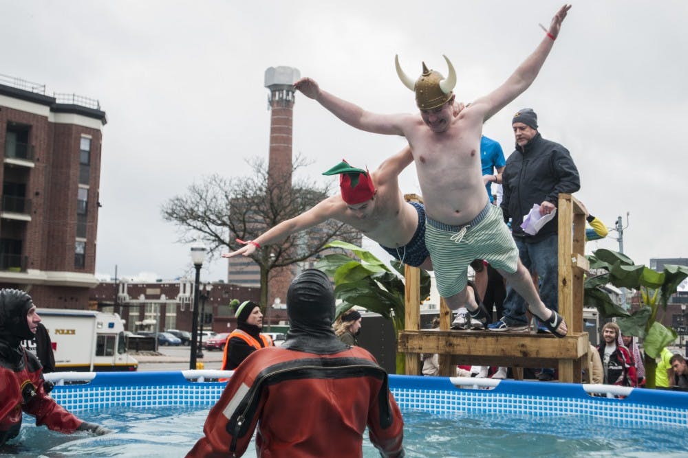 Biosystems engineering sophomore Daniel Farchone, left, and finance sophomore Jake Velisek belly-flop together during the Lansing Polar Plunge on Feb. 12, 2017 at Cooley Law School Stadium in Lansing. Plungers endured 38 degree water, and the event raised approximately $80,000 to support Special Olympics Michigan. 