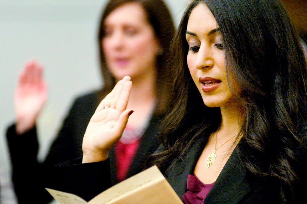 Law graduate Jehan Farrag takes an oath as she and 21 other graduates swear in as lawyers Wednesday night inside the College of Law building. Graduates were admitted to State Bar of Michigan, allowing them to practice law within the state. Justin Wan/The State News