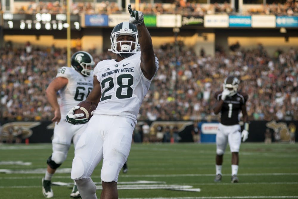 <p>Freshman running back Madre London points to the crowd after scoring a touchdown on Sept. 4, 2015, during a game against Western Michigan at Waldo Stadium in Kalamazoo, Mich. The Spartans beat the Broncos, 37-24. State News File Photo</p>