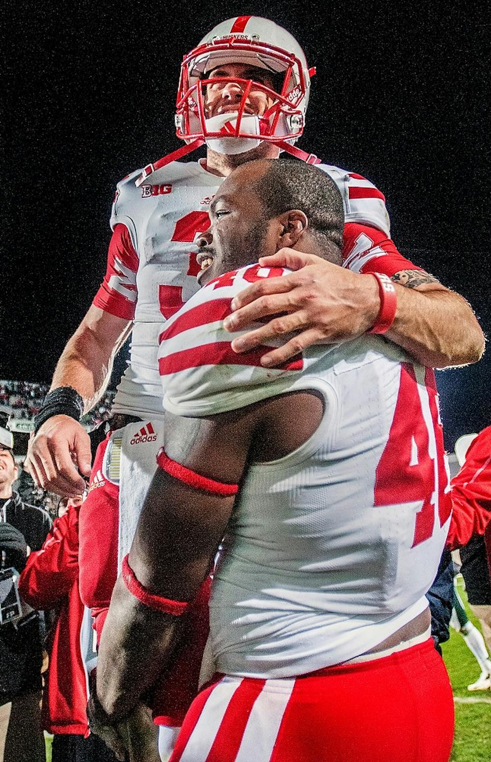 Nebraska quarterback Taylor Martinez celebrates with senior defensive end Eric Martin after the game Nov. 3, 2012, at Spartan Stadium. The Spartans had the lead going into the final minutes of the game but lost 28-24 as Nebraska was able to score with only 6 seconds remaining. Adam Toolin/The State News