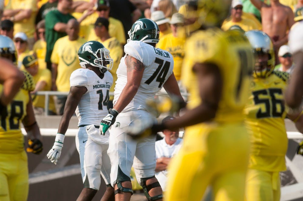 <p>Senior wide receiver Tony Lippett, 14, celebrates scoring a touchdown with sophomore offensive tackle Jack Conklin during the game against Oregon on Sept. 6, 2014, at Autzen Stadium in Eugene, Ore. The Spartans lost to the Ducks, 46-27. Julia Nagy/The State News</p>