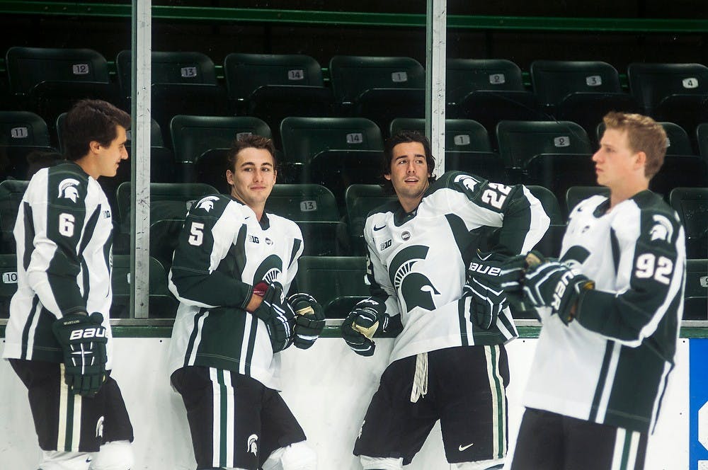 	<p>From left, freshman defenseman Chris Knudson, junior defender R.J. Boyd, senior forward Lee Reimer, and sophomore forward David Bondra wait for a team photo on the side of the ice after media day, Sept. 25, 2013, at Munn Ice Arena. The annual Green and White Game is scheduled for Oct. 5, 2013, before an exhibition against Western Ontario on Oct. 9. Danyelle Morrow/The State News</p>