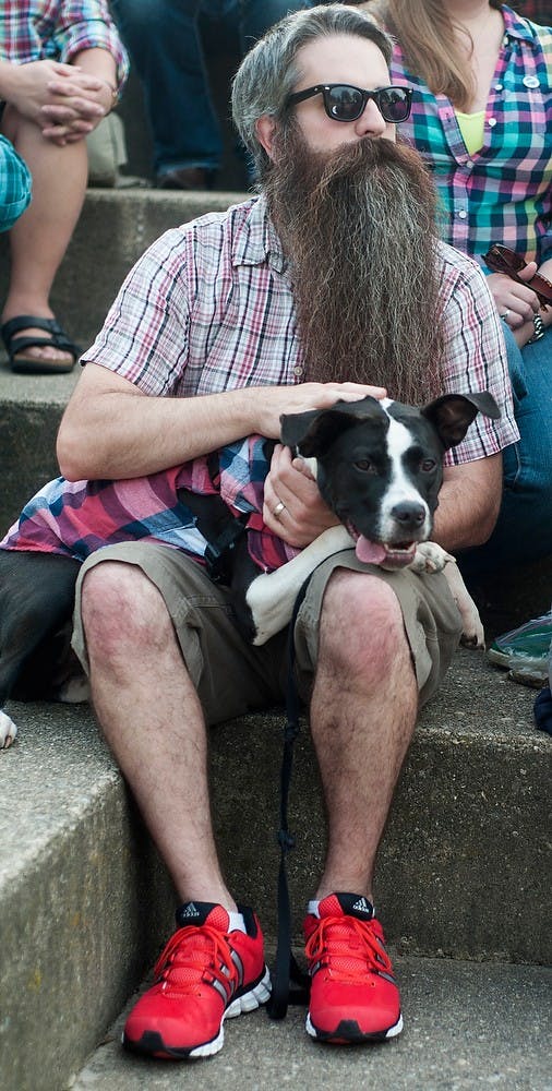 	<p>Lansing resident John Buckler and his dog Cora dress in plaid and hang out while they wait for a group photo to be taken Friday at the Brenke Fish Ladder. Buckler heard about Plaidurday from his friend and <span class="caps">MSU</span> alumnus Justin &#8220;Bugsy&#8221; Sailor, who created the event two years ago to celebrate plaid. Margaux Forster/The State News</p>