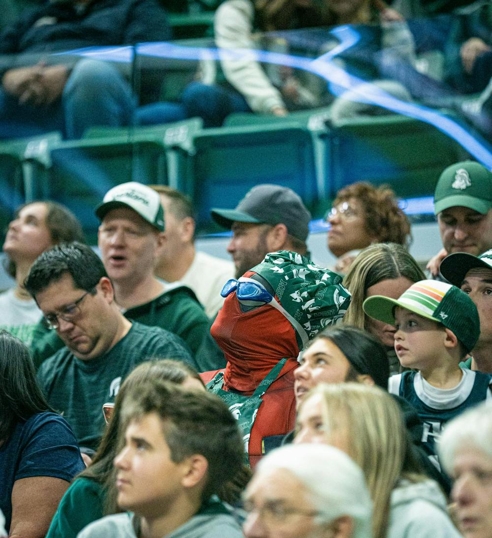 <p>A fan dressed as Deadpool with swimming goggles and a bandana wrapped around his head sits and watches the jumbotron during the MSU versus Toledo men's basketball game at the Breslin Center in East Lansing, Michigan on Tuesday, Dec. 16, 2025.</p>