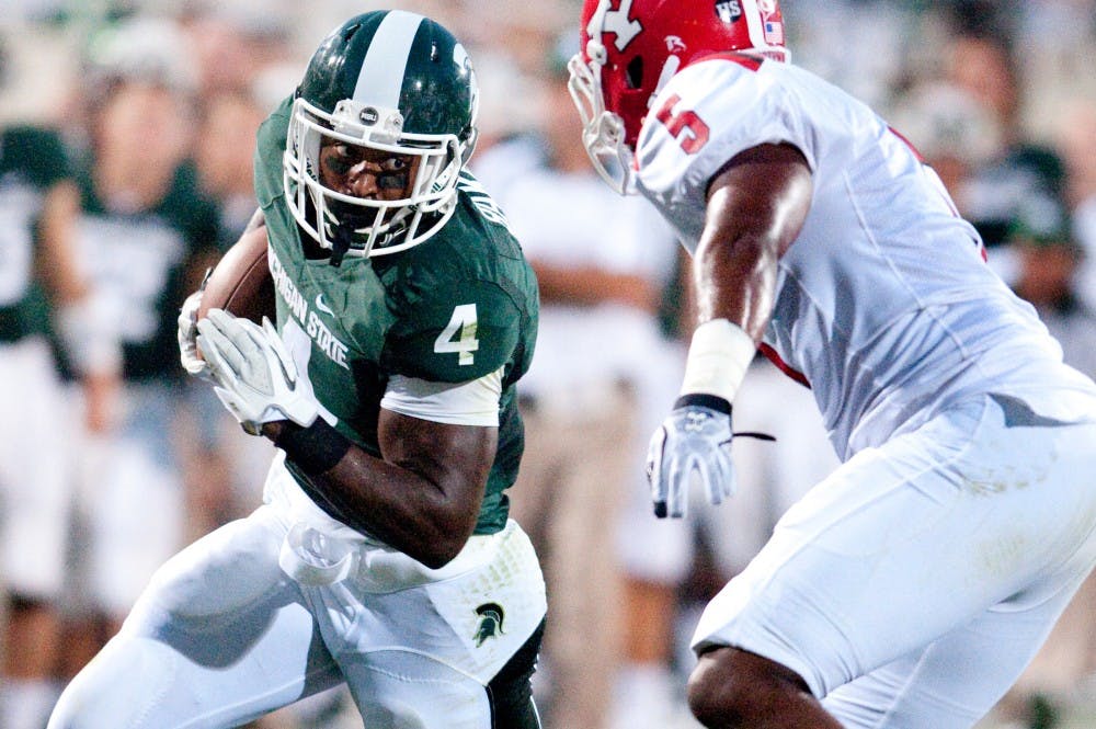 	<p>Junior running back Edwin Baker tries to shake Penguins safety Jeremy Edwards as he nears the endzone. The Spartans defeated Youngstown State, 28-6, Friday night at Spartan Stadium. Josh Radtke/The State News</p>