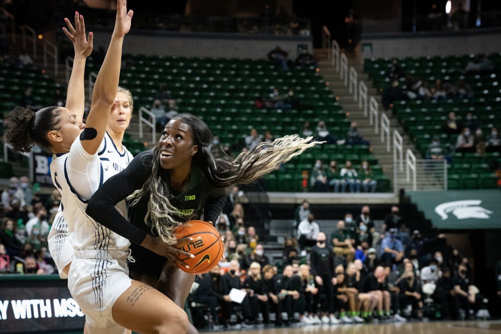 Junior forward Jayla James (20) gets past Penn State’s redshirt freshman guard Leilani Kapinus (5) during a game on Feb. 21, 2022 at the Breslin Center. The Spartans lost to the Lady Lions 79-71.