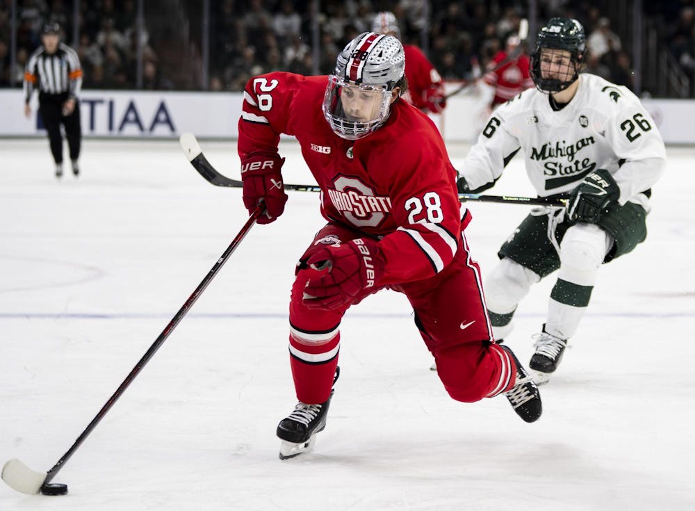 OSU junior defense William Smith (25) takes the puck in the Munn Ice Arena on March 14, 2026. Ohio State defeated Michigan State 3-2 in overtime. 