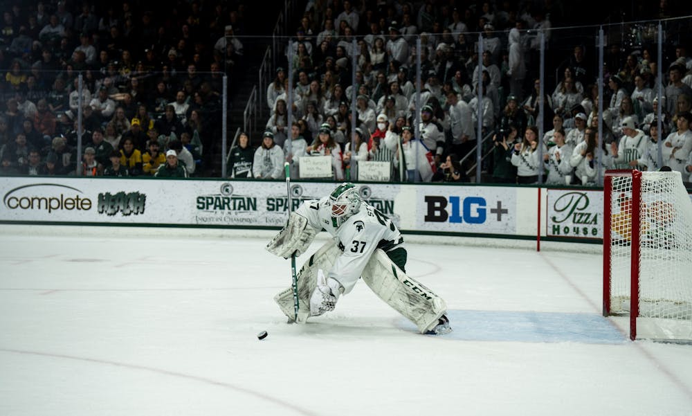 Graduate student goalkeeper Dylan St. Cyr (37) passes the puck to one of his teammates during a game against the University of Michigan at Munn Ice Arena on Dec. 9, 2022. The Spartans defeated the Wolverines 2-1. 