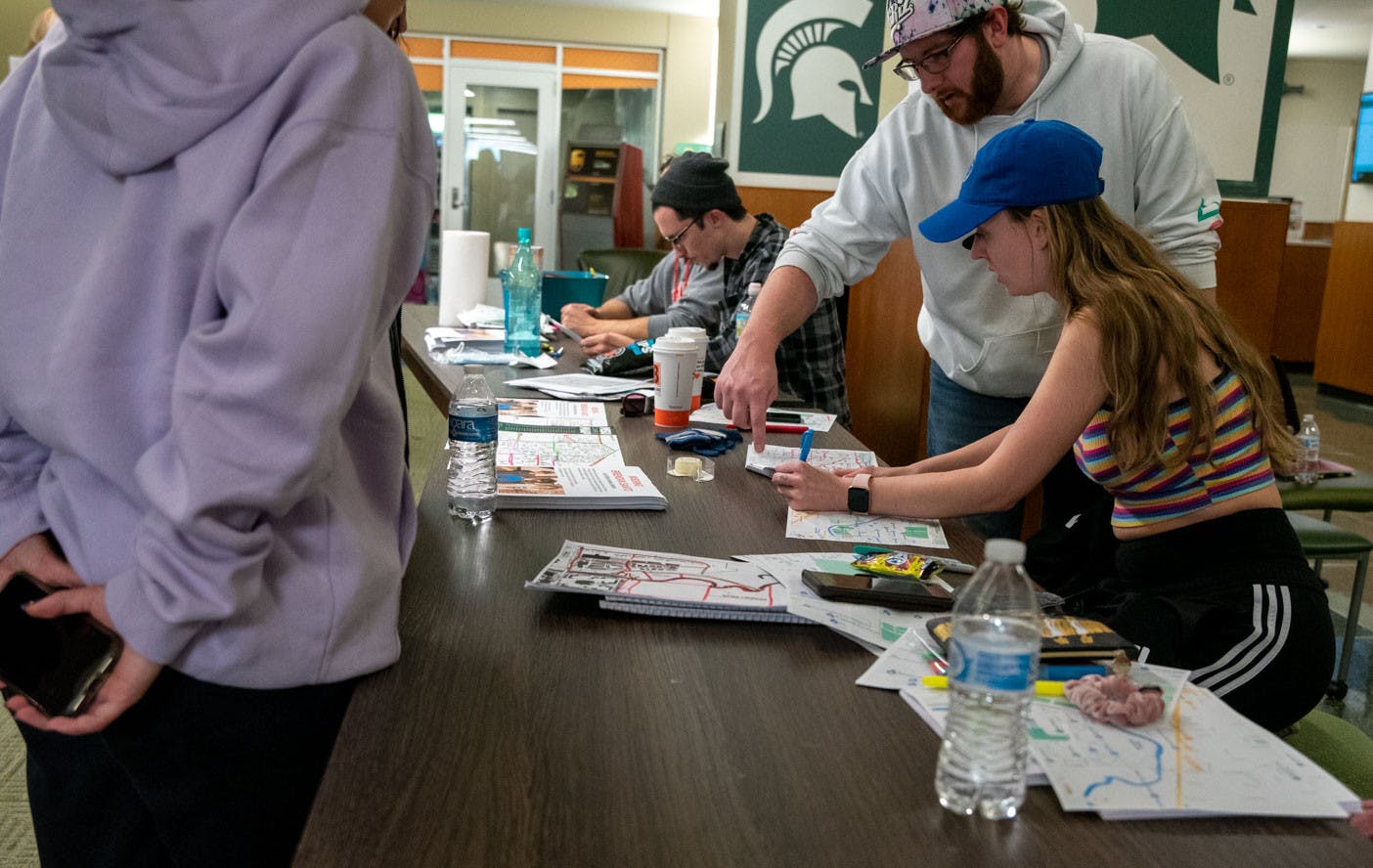 <p>Volunteers help guide search parties at the MSU Union by handing out maps on what areas have not been searched yet. Volunteers came together on Nov. 6 to look for Brendan Santo, who went missing on campus on Oct. 29. Shot on Nov. 6, 2021.</p>