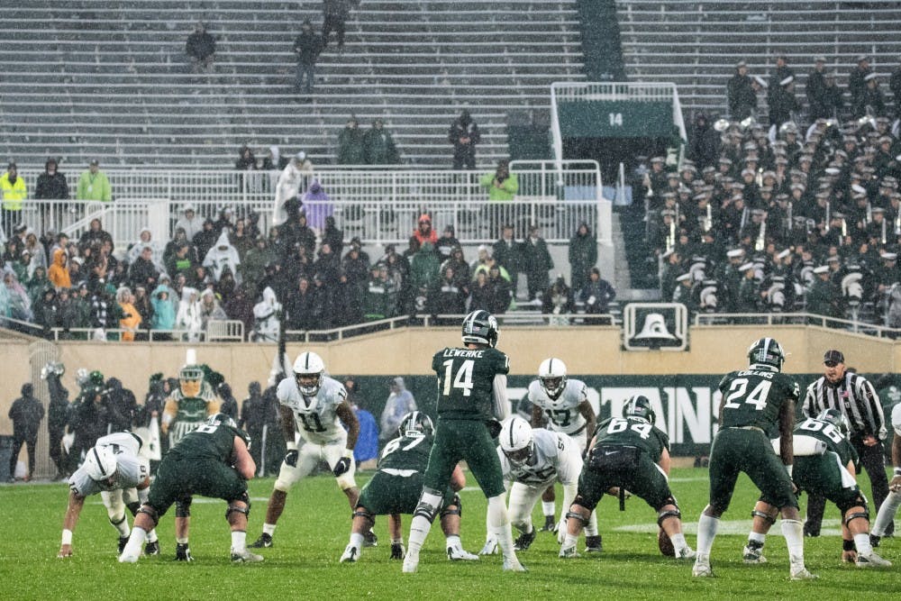 <p>Redshirt senior quarterback Brian Lewerke (14) prepares to take a snap during the game against Penn State on Oct. 26, 2019 at Spartan Stadium. The Spartans fell to the Nittany Lions, 28-7.</p>