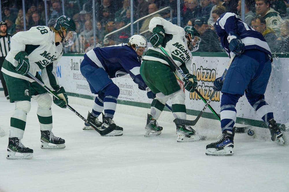 <p>Senior defenseman Nash Nienhuis (4) fighting for the puck during a game against Penn State at the Munn Ice Arena on Nov. 10, 2023.</p>