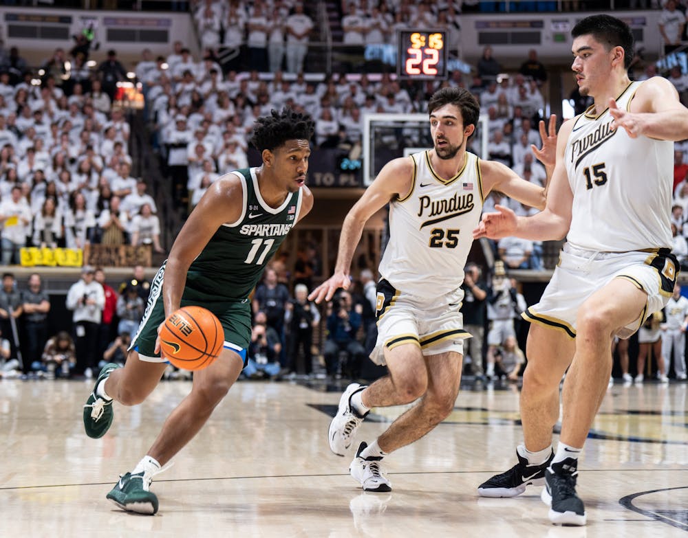 <p>Junior guard A.J. Hoggard (11) drives the ball with Purdue's junior guard Ethan Morton (25) and junior center Zach Edey (15) guarding him during a game against Purdue at Mackey Arena on Jan. 29, 2023. The Spartans lost to the Boilermakers 77-61.</p>