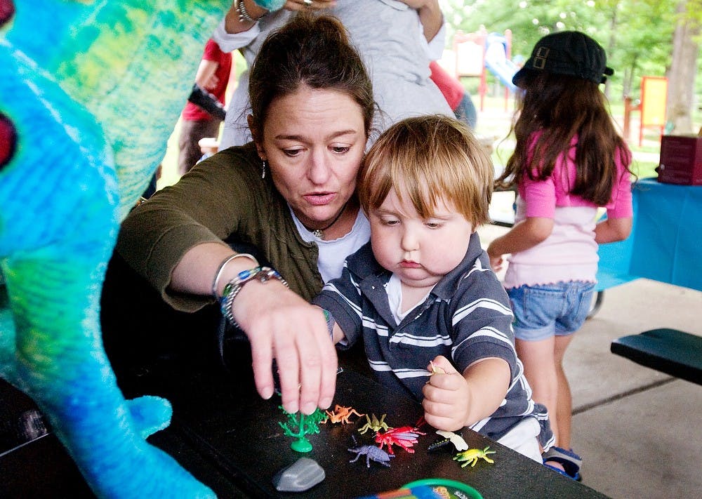 	<p>Charlie Waller, 3, plays with some new toys with family friend Shannon Harkins-Padgitt on June 15, 2011, at the Potter Park Zoo. After a long day exploring the zoo, Charlie and friends and family had a barbecue, cake, and opened presents outside the zoo. Matt Radick/The State News</p>