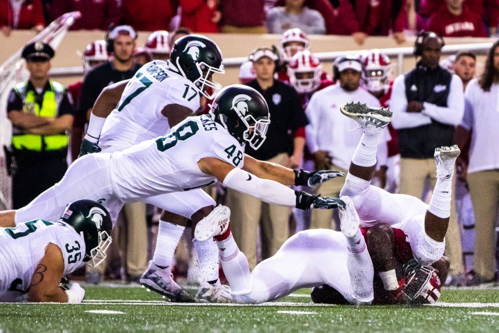 <p>An Indiana ball carrier is tackled by a group of Spartans during the game against Indiana on Sept. 22, 2018 at Memorial Stadium. The Spartans defeated the Hoosiers, 35-21.</p>