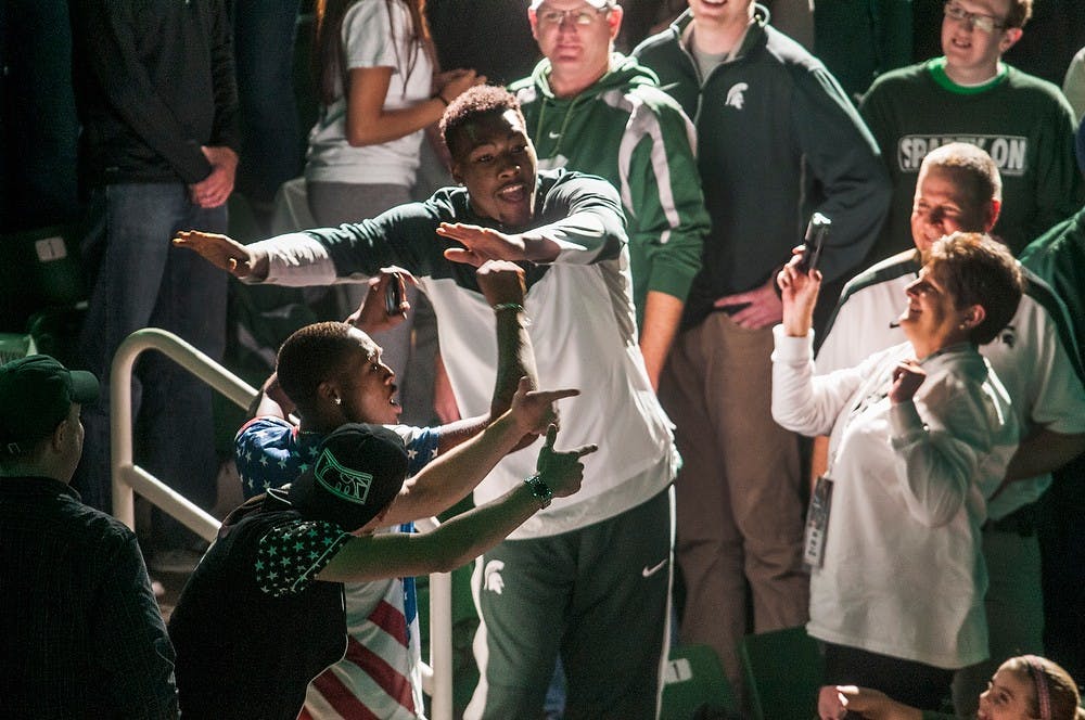 <p>Freshman forward Javon Bess dances with fans as he is introduced Oct. 24, 2014, during Midnight Madness at Breslin Center. Head Coach Suzy Merchant performed as Beyonce and Head Coach Tom Izzo performed as a member of KISS. Erin Hampton/The State News</p>