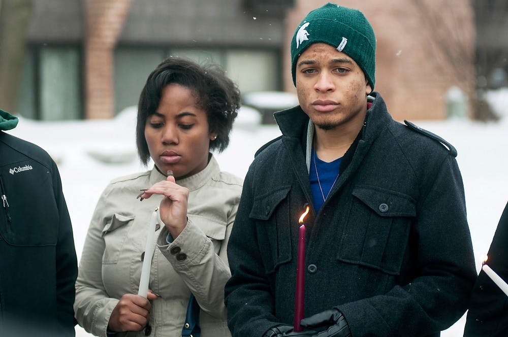 	<p>Political science senior Chris McClain, right, holds a candle during a moment of silence at a candlelight vigil held for hospitality business sophomore Dominique Nolff on Feb. 2, 2014, on Waters Edge Drive. Nolff died following a shooting Jan. 31, 2014. Danyelle Morrow/The State News</p>