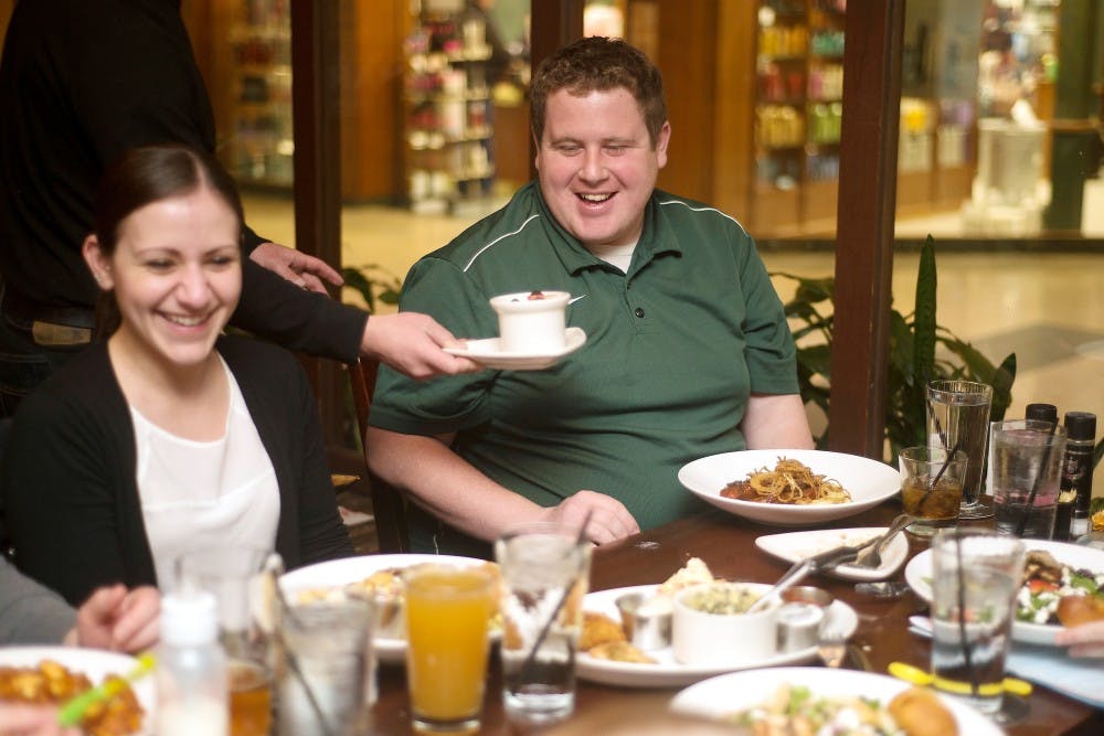 <p>Houlihan's host Gianna Ferraro serves Lansing residents Becky Gaugier, left, and Keith Kelley on March 3, 2015, while eating at Houlihan's, 5732 W. Saginaw Highway in Lansing. Gaugier and Kelley were invited to eat out by their friends. Emily Nagle/The State News</p>