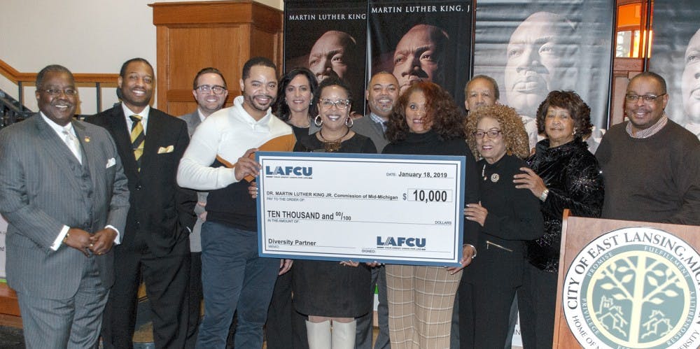 <p>Kelli Ellsworth Etchison representing LAFCU, center, presents a ceremonial check to the Dr. Martin Luther King Jr. Commission of Mid-Michigan | Photo courtesy of Jan Jenkins, director of public relations for Edge Publicom&nbsp;</p>