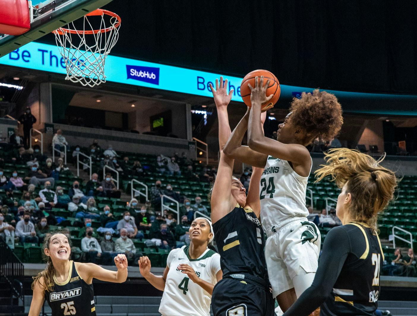 <p>Senior guard Nia Clouden (24) fights through Bryant defense to score during the fourth quarter of the game. The Spartans crushed the Bulldogs, 100-60, which led coach Suzy Merchant to her 300th win with Michigan State on Nov. 19, 2021.</p>