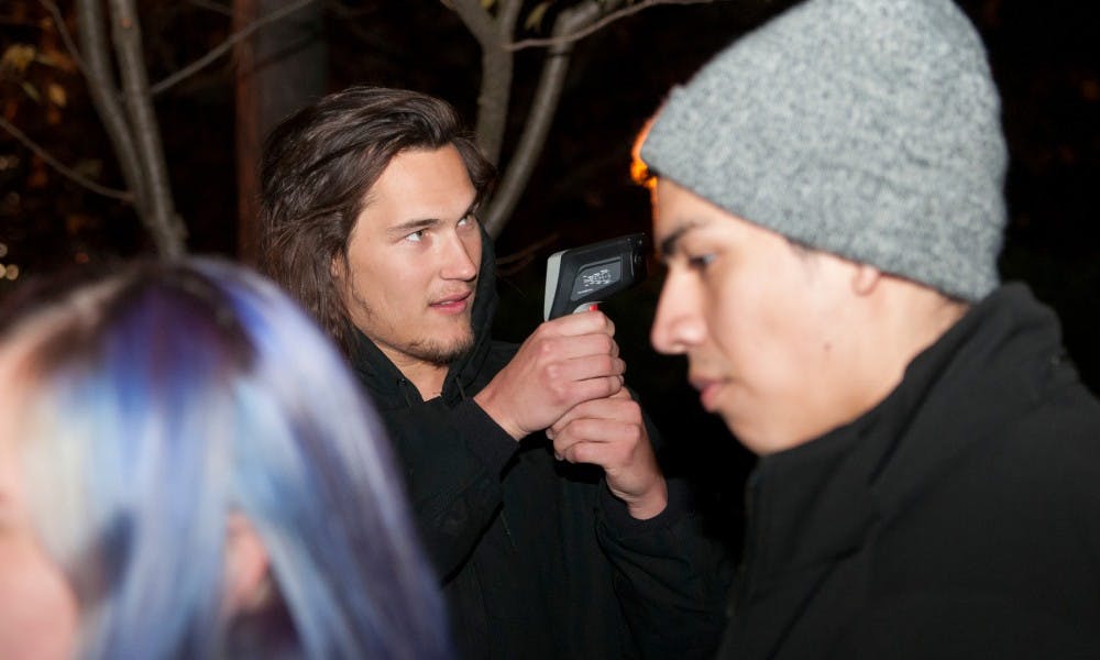 <p>Neuroscience freshman Jared Schlender points a temperature gun at Beaumont Tower during the paranormal society's investigation on Nov. 6, 2015 at Beaumont Tower.</p>