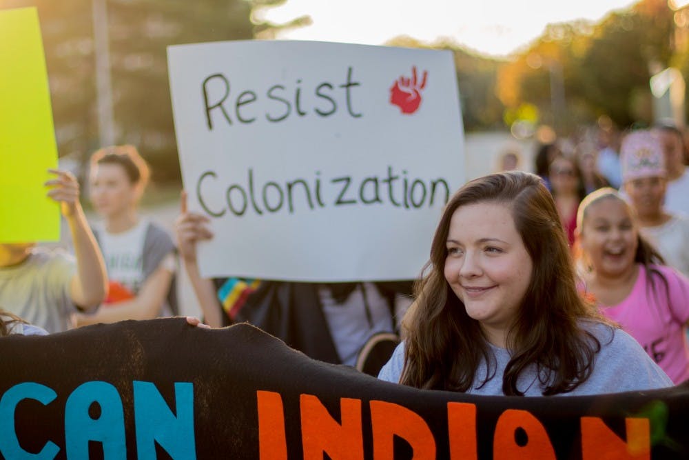 Biochemistry senior Jillian Mutchler marches on Oct. 9, from the Beaumont Tower to the rock on Farm Lane. The march led to an event at the rock on Farm Lane in celebration of Indigenous Peoples Day.