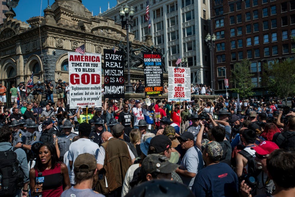 A religious group holds signs in protest on July 19, 2016 at Public Square in Cleveland, Ohio. Hundreds of protestors gathered together to protest the recent violence between police officers and the public.