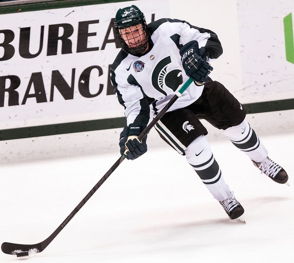 	<p>Freshman defensemen John Draeger passes the puck over to a teammate Friday night, Nov. 30, 2012, at Munn Ice Arena. The Ohio State Buckeyes defeated the Spartans, 1-0, with a late goal in the third period. Adam Toolin/The State News</p>
