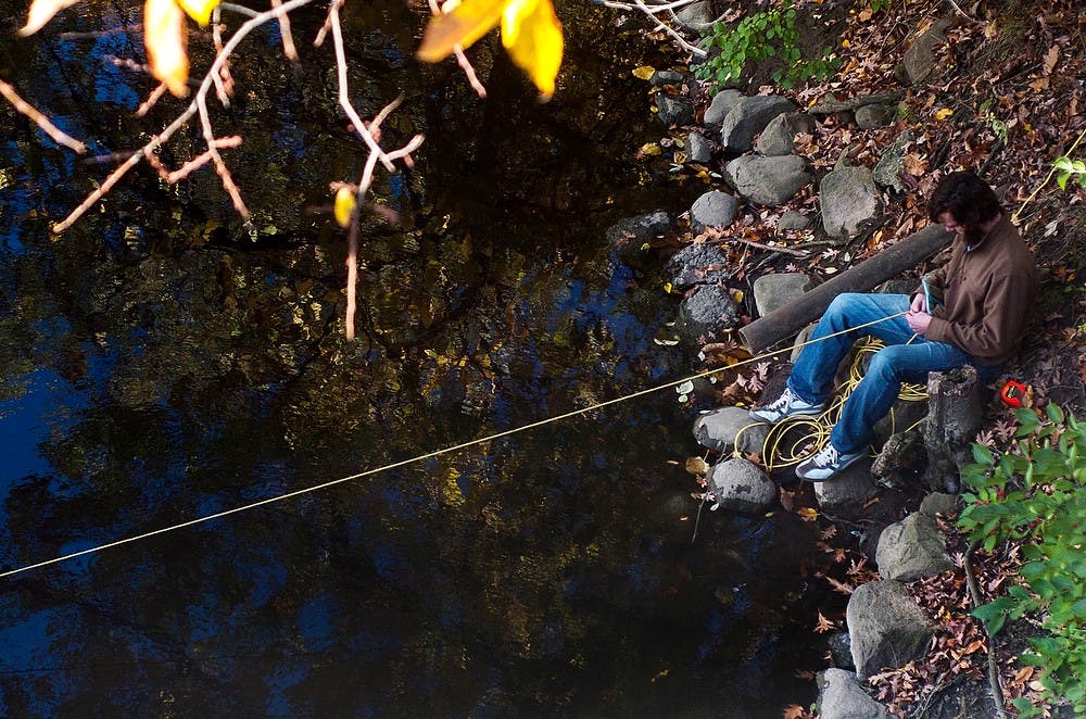 	<p>Hydrogeology laboratory technician Blaze Budd takes measurements of the Red Cedar River to gauge its water quality Oct. 24, 2013, near Erickson Hall. Budd travels around the state to gauge water quality and take various measurements. Cayden Royce/The State News</p>