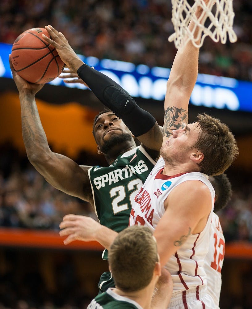 <p>Senior guard/forward Branden Dawson attempts a shot over Oklahoma forward Ryan Spangler March 27, 2015, during the East Regional round of the NCAA Tournament at the Carrier Dome in Syracuse, New York. At halftime, the Spartans were lead by the Sooners, 31-27. Erin Hampton/The State News</p>