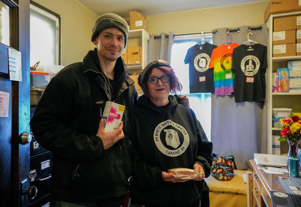 James Saylor, who has previously worked with the organization and is receiving services from them, and co-founder and Executive Director of Punks with Lunch and Director of the Harm Reduction Hub Julia Miller pose for a photo in the main office at Punks with Lunch, a non-profit outreach organization that supplies necessities and harm reduction as well as provides Narcan and recovery resources in Lansing. Photographed on Nov. 20, 2023.  