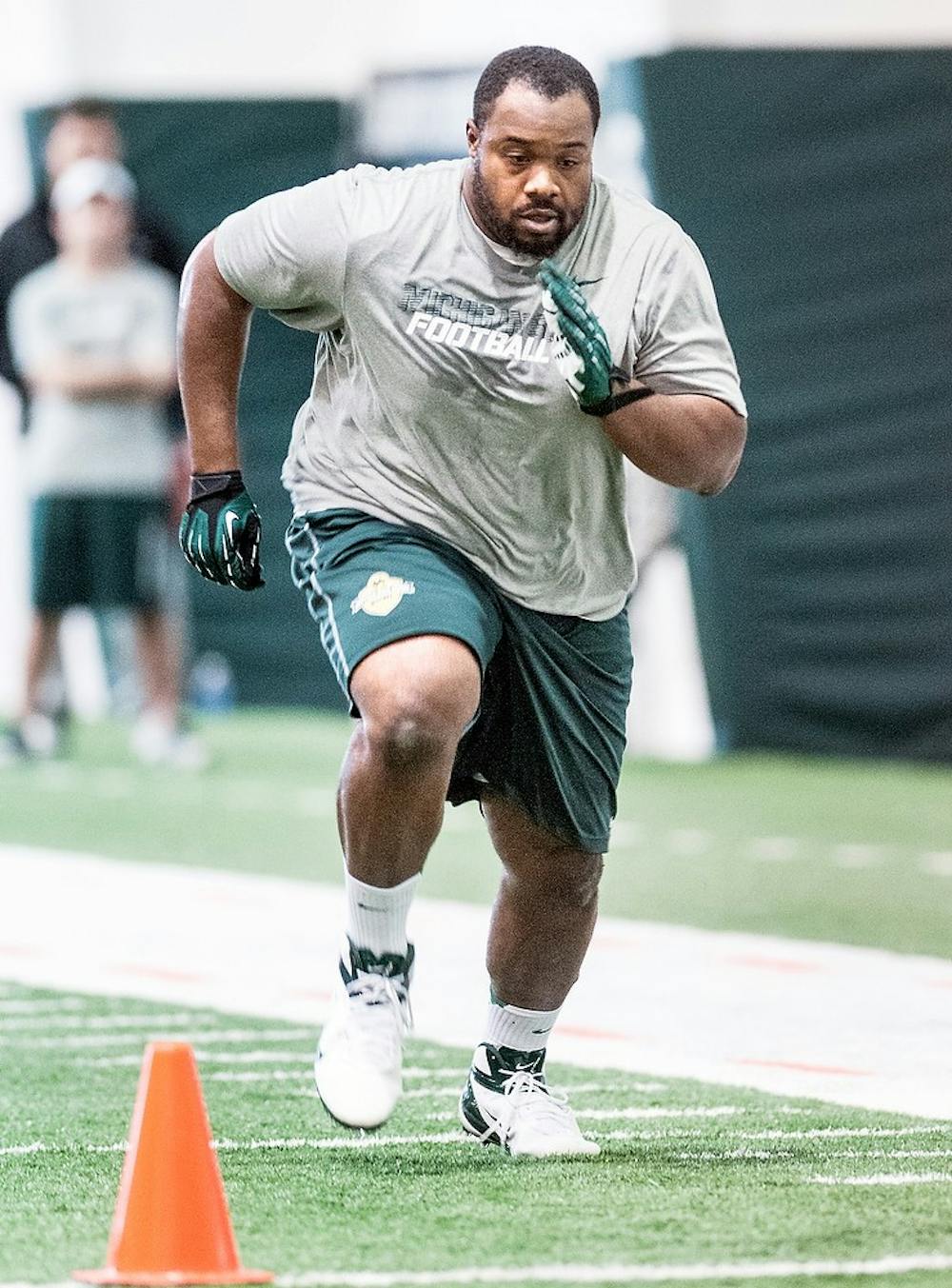 Senior nose tackle Anthony Rashad White runs a practice drill March 13, 2013, during Pro Day at the Duffy Daugherty Football Building. MSU football holds the annual event for NFL scouts and coaches to get a closer look at the Spartan's NFL prospects. Adam Toolin/The State News