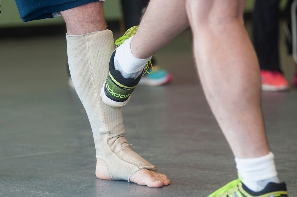 <p>Head instructor and owner Daniel Smith demonstrates where to kick on Lansing resident Kyle Rogers during a self-defense class at American Martial Arts and Fitness Academy in Lansing. Smith has been teaching self-defense for more than 30 years. Danyelle Morrow/The State News</p>